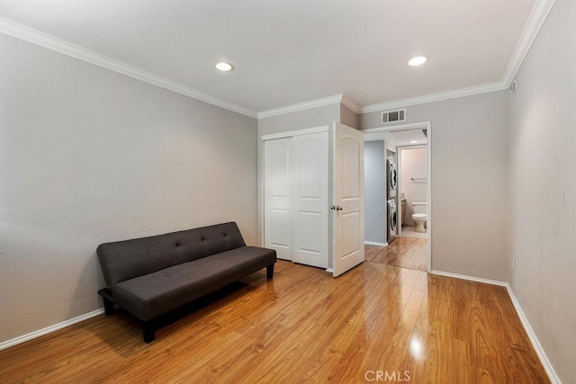 5325 Newcastle Ave Unit 319, Encino, CA 91316 - living area with stacked washer / drying machine, light wood finished floors, crown molding, and recessed lighting