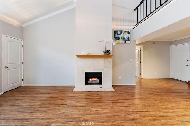5325 Newcastle Ave Unit 319, Encino, CA 91316 - unfurnished living room with wood finished floors, a fireplace, ornamental molding, and a towering ceiling
