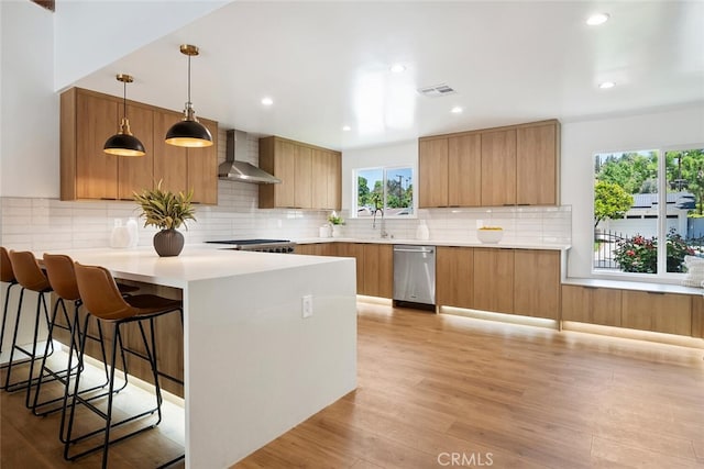 4701 Deseret Dr, Woodland Hills, CA 91364 - kitchen featuring wall chimney range hood, stainless steel dishwasher, modern cabinets, a peninsula, and light wood-type flooring
