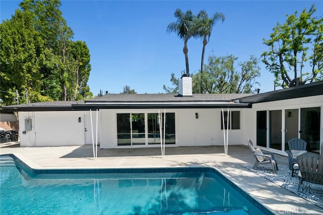 4701 Deseret Dr, Woodland Hills, CA 91364 - back of house featuring a chimney, stucco siding, a patio, and an outdoor pool
