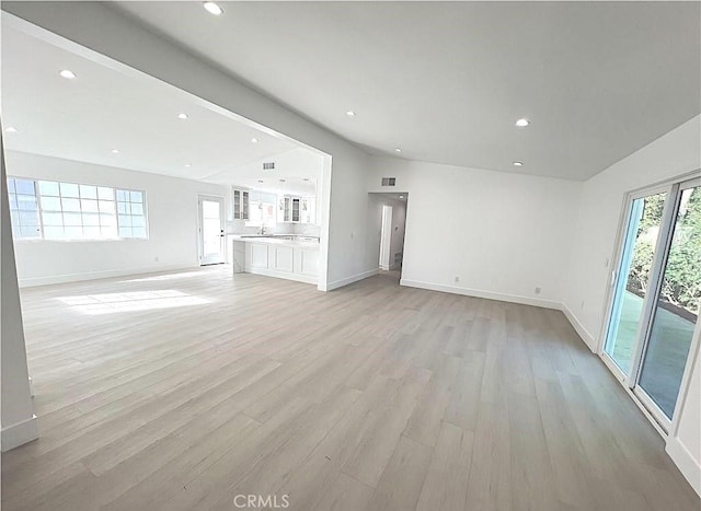 21541 Yucatan Ave, Woodland Hills, CA 91364 - unfurnished living room with light wood finished floors, vaulted ceiling, and recessed lighting