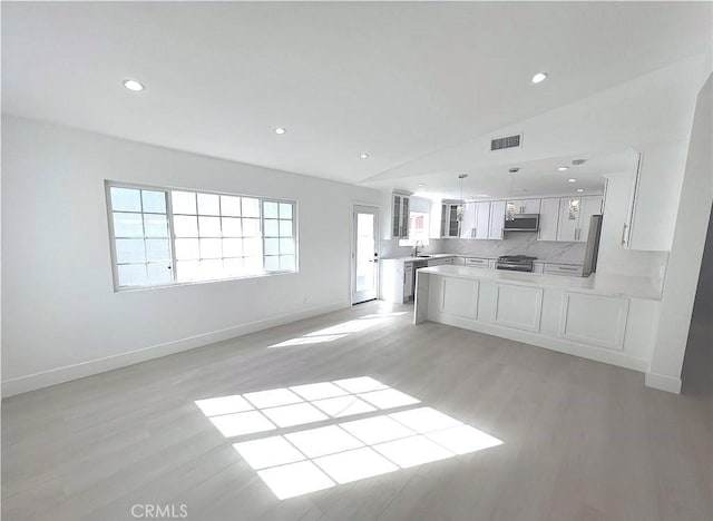 21541 Yucatan Ave, Woodland Hills, CA 91364 - kitchen featuring light wood finished floors, lofted ceiling, open floor plan, a peninsula, and glass insert cabinets