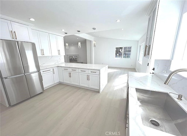 21541 Yucatan Ave, Woodland Hills, CA 91364 - kitchen with freestanding refrigerator, a peninsula, recessed lighting, light wood-style floors, and light stone countertops
