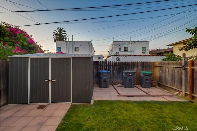 2975 Fernwood Ave, Lynwood, CA 90262 - yard at dusk featuring a shed, a fenced backyard, and a patio