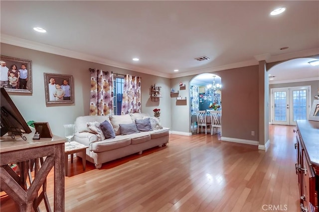 2975 Fernwood Ave, Lynwood, CA 90262 - living room featuring arched walkways, french doors, ornamental molding, light wood-style floors, and recessed lighting