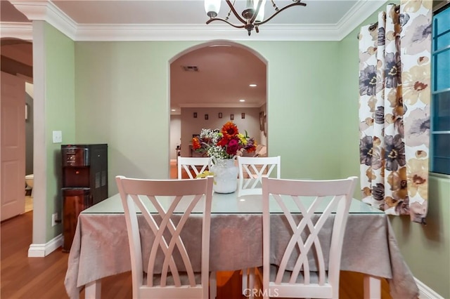 2975 Fernwood Ave, Lynwood, CA 90262 - dining room with arched walkways, crown molding, a chandelier, wood finished floors, and recessed lighting