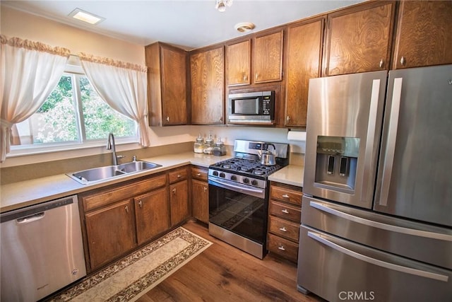20716 Community St, Winnetka, CA 91306 - kitchen featuring stainless steel appliances, dark wood-style floors, brown cabinetry, and light countertops