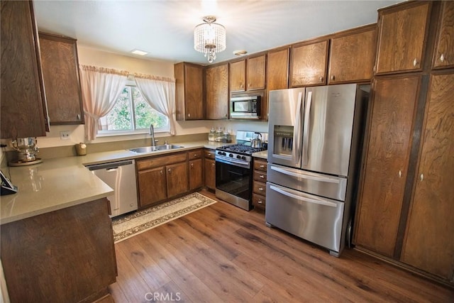 20716 Community St, Winnetka, CA 91306 - kitchen featuring appliances with stainless steel finishes, dark wood-type flooring, a chandelier, and light countertops