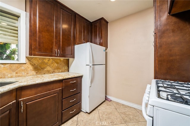 3986 Tomlinson, Riverside, CA 92503 - kitchen with white appliances, tasteful backsplash, light stone counters, light tile patterned floors, and dark brown cabinetry
