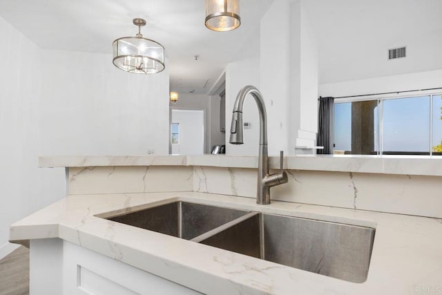 11375 Affinity Ct Unit 206, San Diego, CA 92131 - kitchen featuring decorative backsplash, light stone countertops, pendant lighting, and wood finished floors