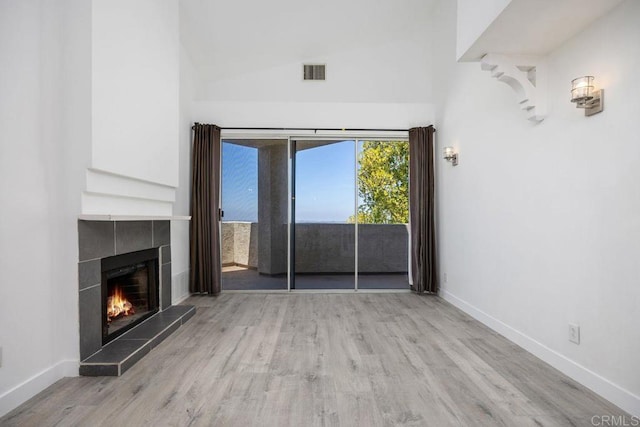 11375 Affinity Ct Unit 206, San Diego, CA 92131 - unfurnished living room with wood finished floors, a tile fireplace, and lofted ceiling