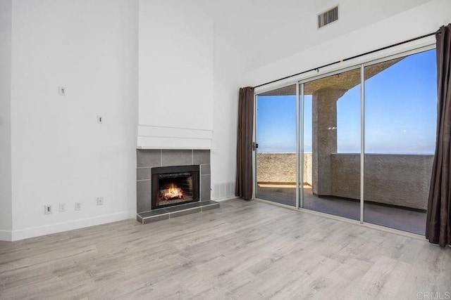 11375 Affinity Ct Unit 206, San Diego, CA 92131 - unfurnished living room with wood finished floors, a tiled fireplace, and a high ceiling