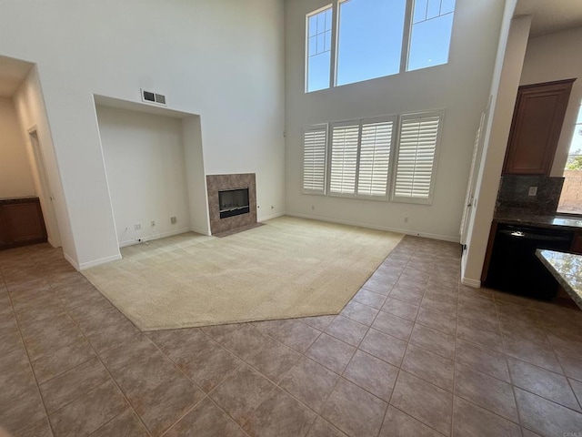 106 Chesapeake Ct, San Marcos, CA 92069 - unfurnished living room with a high ceiling, light colored carpet, plenty of natural light, a tiled fireplace, and light tile patterned floors