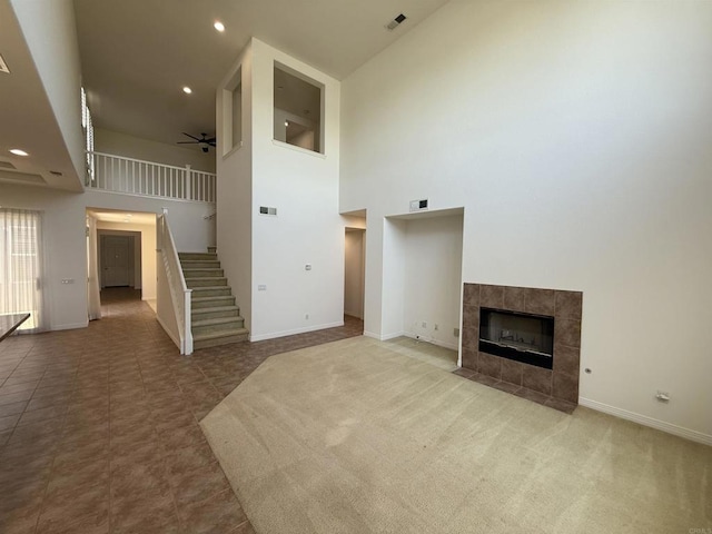 106 Chesapeake Ct, San Marcos, CA 92069 - unfurnished living room featuring stairway, a high ceiling, a ceiling fan, a tile fireplace, and recessed lighting