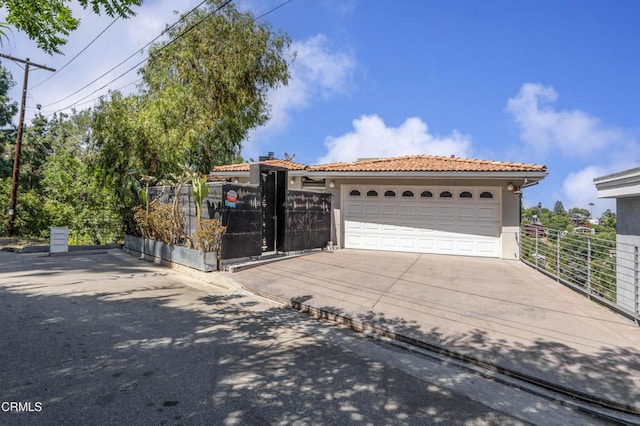 453 Frontenac Ave, Los Angeles, CA 90065 - mediterranean / spanish home featuring a tile roof, stucco siding, concrete driveway, a gate, and a garage