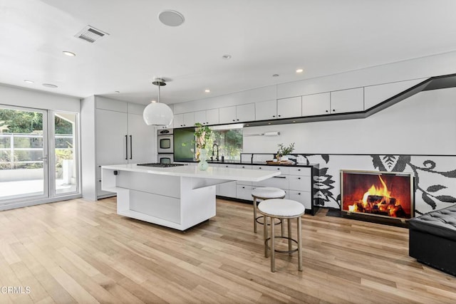 453 Frontenac Ave, Los Angeles, CA 90065 - kitchen featuring a center island, light wood-type flooring, light countertops, gas cooktop, and stainless steel double oven
