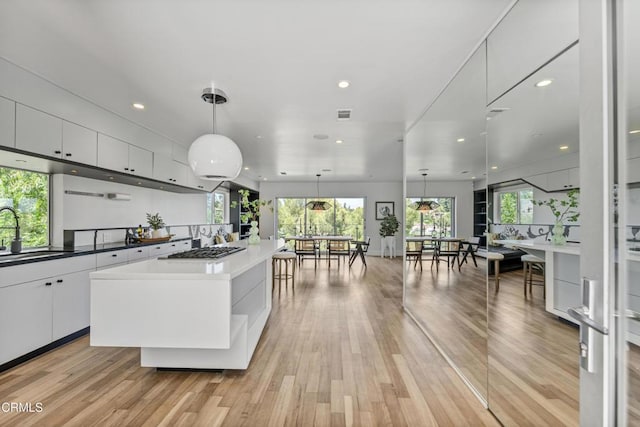 453 Frontenac Ave, Los Angeles, CA 90065 - kitchen with white cabinets, light wood-style flooring, recessed lighting, stainless steel gas stovetop, and a kitchen island