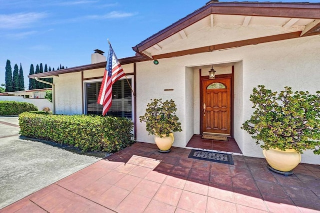 1235 Via Rancho Pkwy, Escondido, CA 92029 - view of exterior entry featuring stucco siding and a chimney