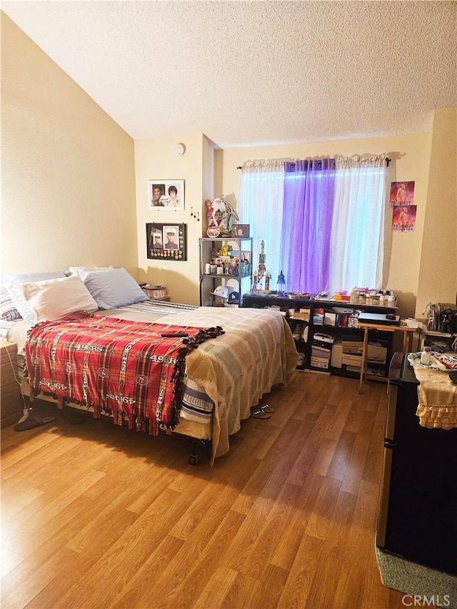 675 N Lark Ellen Ave, Covina, CA 91722 - bedroom with a textured ceiling and wood finished floors