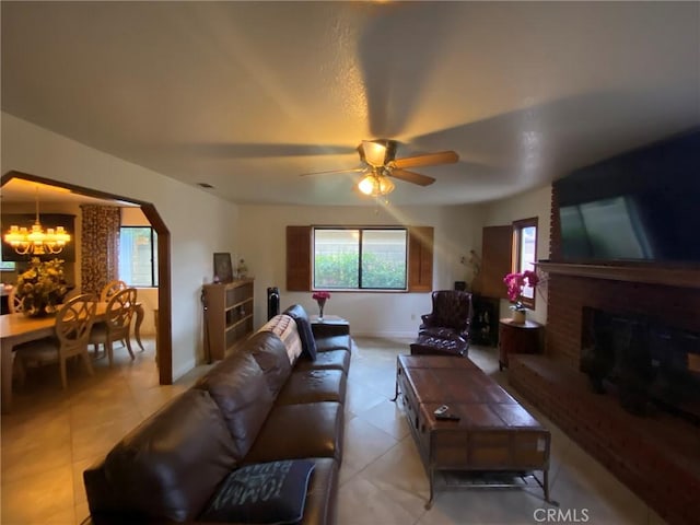 4323 Annisa Ave, Hemet, CA 92544 - living room with a chandelier, light tile patterned floors, a ceiling fan, arched walkways, and a fireplace