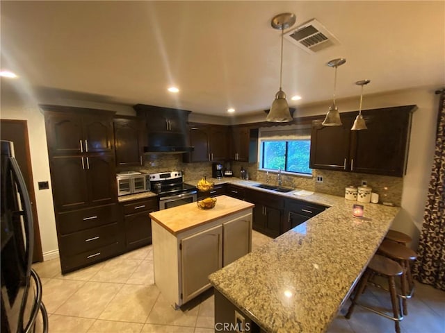 4323 Annisa Ave, Hemet, CA 92544 - kitchen featuring appliances with stainless steel finishes, ventilation hood, a kitchen island, tasteful backsplash, and light stone counters