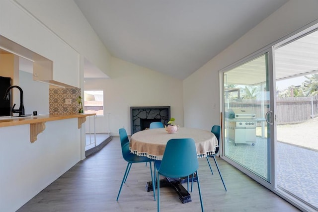 1547 Cochabamba St, San Diego, CA 92154 - dining space with light wood-style flooring, lofted ceiling, and a fireplace