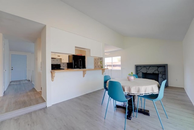 1547 Cochabamba St, San Diego, CA 92154 - dining area with vaulted ceiling, light wood-style floors, and a fireplace