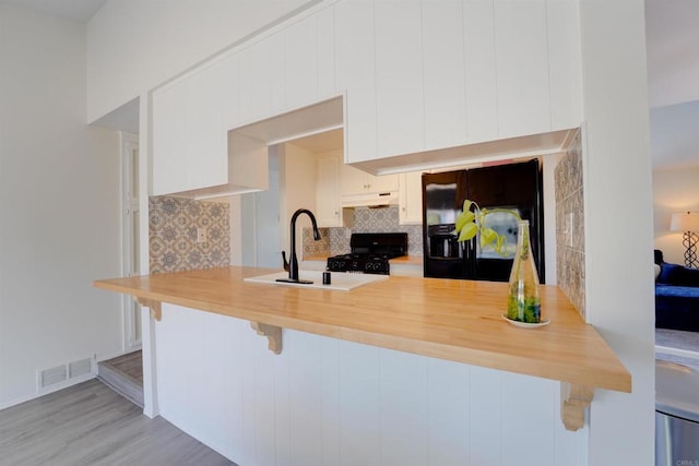1547 Cochabamba St, San Diego, CA 92154 - kitchen with black appliances, a peninsula, under cabinet range hood, and tasteful backsplash