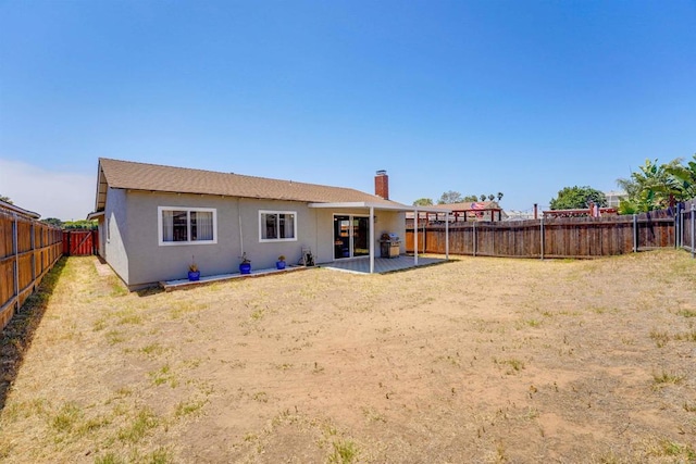1547 Cochabamba St, San Diego, CA 92154 - back of property featuring a fenced backyard, stucco siding, a chimney, and a patio area