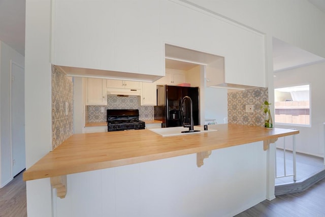 1547 Cochabamba St, San Diego, CA 92154 - kitchen featuring black appliances, wood finished floors, tasteful backsplash, and under cabinet range hood