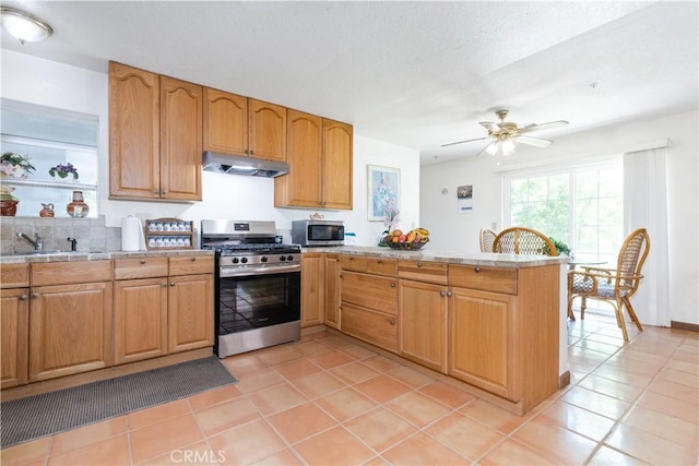 65380 San Lucas Rd, Lockwood, CA 93932 - kitchen with stainless steel appliances, under cabinet range hood, a peninsula, and light tile patterned floors