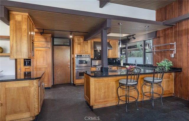 1653 W Cypress Ave, Redlands, CA 92373 - kitchen featuring rail lighting, stainless steel double oven, a peninsula, wall chimney exhaust hood, and wood walls