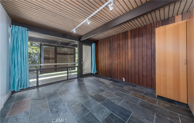 1653 W Cypress Ave, Redlands, CA 92373 - spare room featuring wood walls, track lighting, stone finish floors, and beamed ceiling
