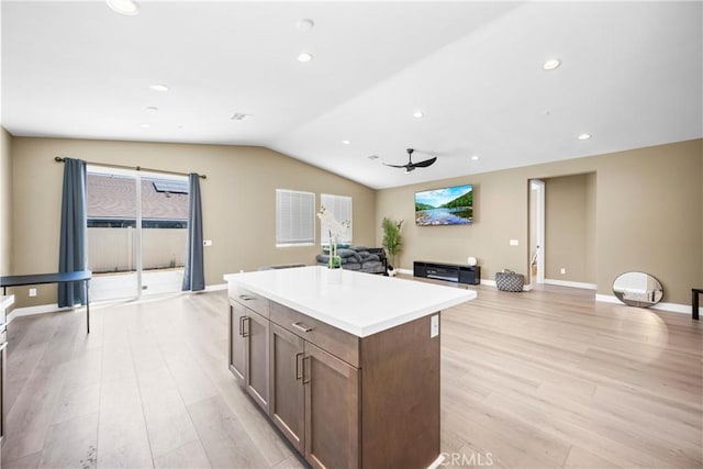 27741 Solitude Ave, Moreno Valley, CA 92555 - kitchen with light wood-style floors, lofted ceiling, a kitchen island, open floor plan, and light countertops
