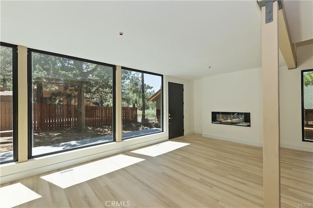 216 Leonard Ln, Big Bear, CA 92386 - unfurnished living room with wood finished floors, healthy amount of natural light, and a glass covered fireplace