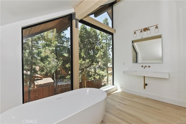 216 Leonard Ln, Big Bear, CA 92386 - bathroom with a soaking tub, healthy amount of natural light, wood finished floors, and lofted ceiling