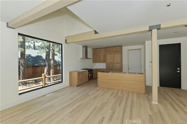 216 Leonard Ln, Big Bear, CA 92386 - kitchen featuring wall chimney exhaust hood, light wood-type flooring, brown cabinetry, gas range oven, and vaulted ceiling