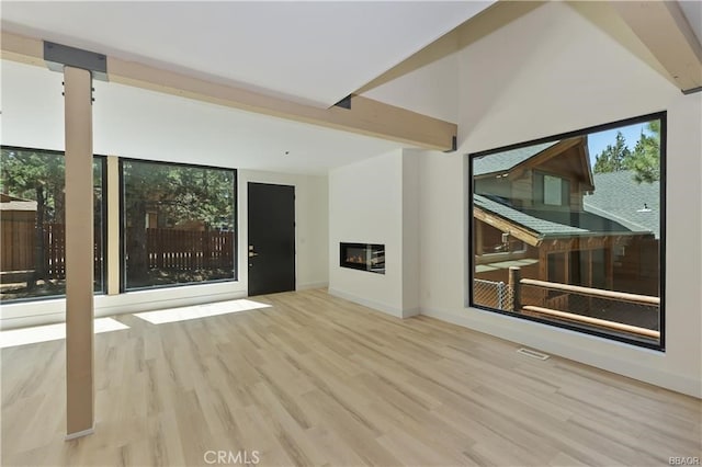 216 Leonard Ln, Big Bear, CA 92386 - unfurnished living room with beam ceiling, a glass covered fireplace, and wood finished floors