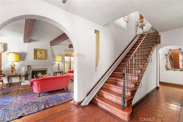 1811 N Flower St, Santa Ana, CA 92706 - stairs with tile patterned floors, a lit fireplace, and arched walkways