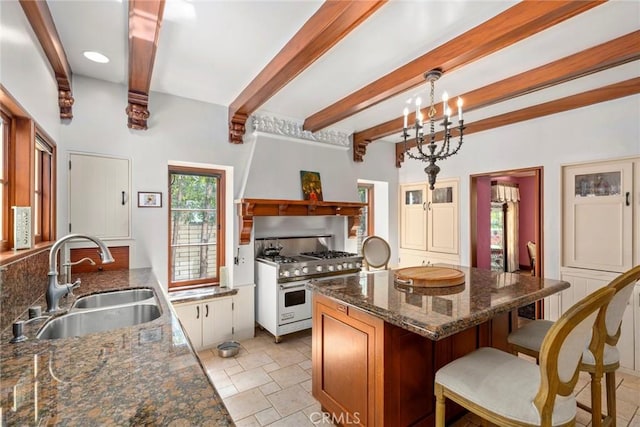 1811 N Flower St, Santa Ana, CA 92706 - kitchen featuring range with two ovens, beam ceiling, a kitchen island, a breakfast bar, and dark stone countertops