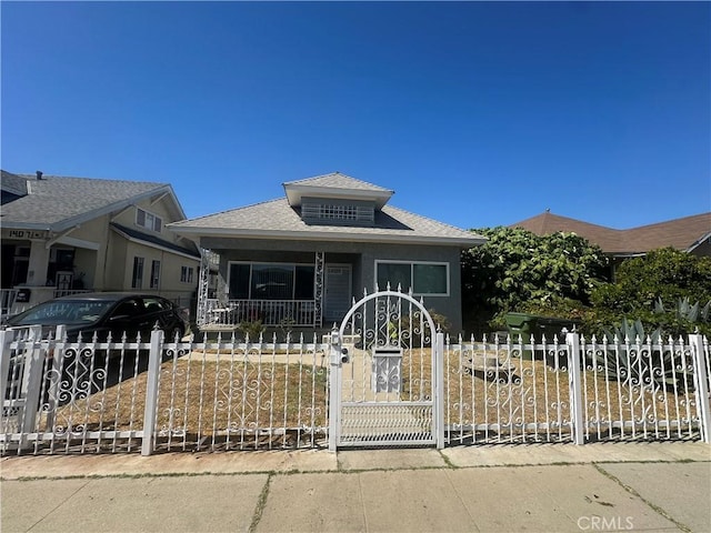 1409 E 41st Pl, Los Angeles, CA 90011 - bungalow with a fenced front yard, a gate, a porch, and roof with shingles