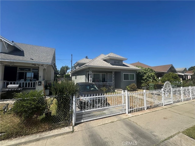 1409 E 41st Pl, Los Angeles, CA 90011 - bungalow featuring a fenced front yard, a porch, a gate, and a shingled roof