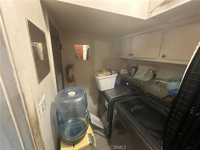 1409 E 41st Pl, Los Angeles, CA 90011 - laundry area with washing machine and clothes dryer, light tile patterned floors, and cabinet space
