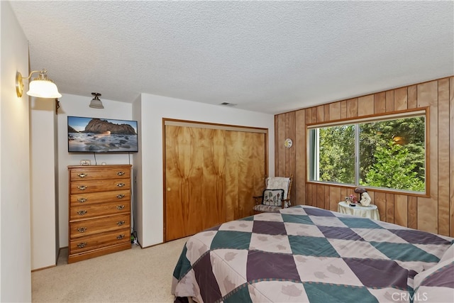 325 Brentwood, Lake Arrowhead, CA 92352 - bedroom featuring wooden walls, a closet, light carpet, and a textured ceiling
