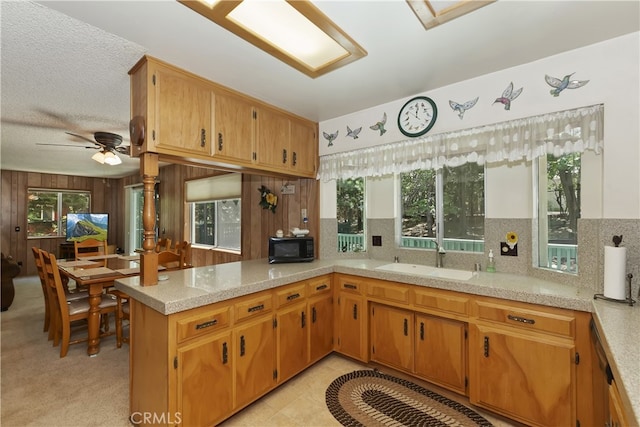 325 Brentwood, Lake Arrowhead, CA 92352 - kitchen featuring light countertops, black microwave, tasteful backsplash, a ceiling fan, and a peninsula