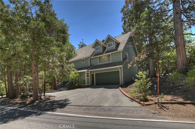325 Brentwood, Lake Arrowhead, CA 92352 - view of front of home with concrete driveway, a garage, roof with shingles, and stairway