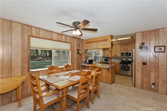 325 Brentwood, Lake Arrowhead, CA 92352 - dining area featuring wood walls, ceiling fan, light colored carpet, and a textured ceiling
