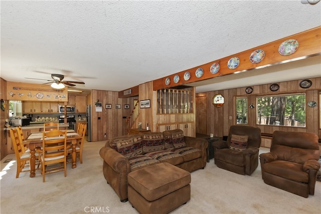 325 Brentwood, Lake Arrowhead, CA 92352 - living room featuring light carpet, a textured ceiling, wood walls, stairway, and ceiling fan