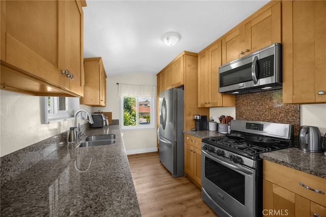 1051 Russell St, La Habra, CA 90631 - kitchen featuring stainless steel appliances, backsplash, light wood-type flooring, vaulted ceiling, and dark stone counters