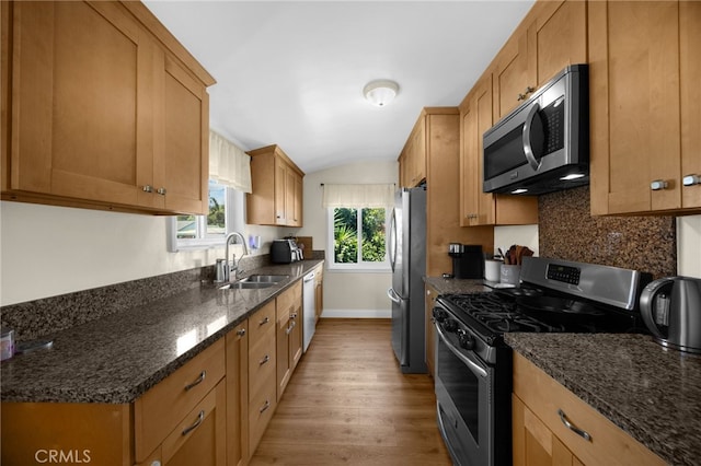 1051 Russell St, La Habra, CA 90631 - kitchen featuring appliances with stainless steel finishes, light wood finished floors, dark stone countertops, tasteful backsplash, and vaulted ceiling